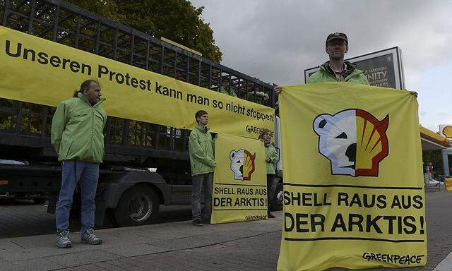 Greenpeace activists make a picket outside a Shell petrol station in Hamburg