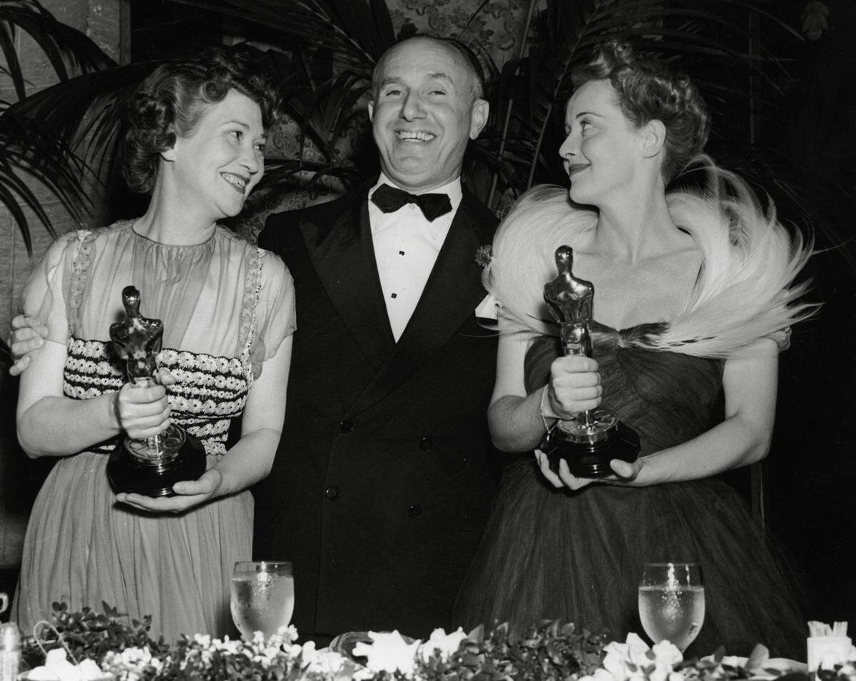 Die Oscar-Preisträgerinnen und ihre Looks gehen in die Geschichte ein. Noch Jahrzehnte später erinnert man sich an die schönsten Roben des wichtigsten Filmpreises der Welt. Bette Davis (rechts) gewann für ihre Rolle in "Jezebel" 1939 einen Oscar als beste Hauptdarstellerin. Ihre Auszeichnung nahm sie in einer Robe mit aufwendigem Federkragen entgegen.  