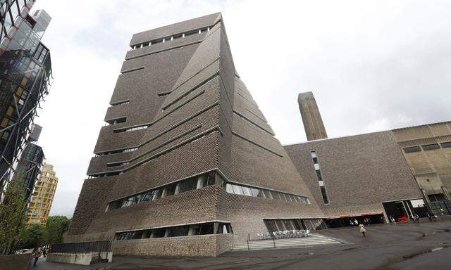 A man stands outside the Switch House during the unveiling of the New Tate Modern in London