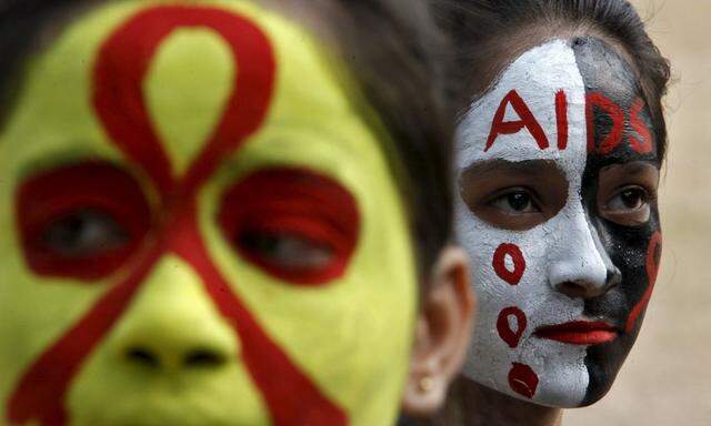 Students wait for their face paint to dry before an AIDS awareness rally inside a school on the eve of World AIDS Day, in Chandigarh