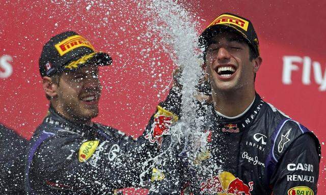Third place finisher Red Bull Formula One driver Vettel of Germany sprays teammate and winner Red Bull Formula One driver Ricciardo of Australia after the Canadian F1 Grand Prix at the Circuit Gilles Villeneuve in Montreal