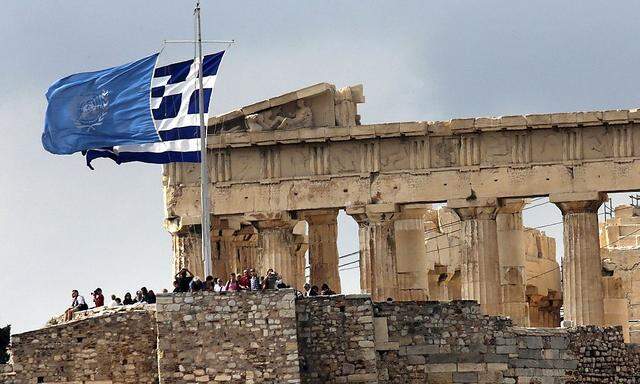 Greek and United Nations flags flutter atop the Athens Acropolis on United Nations Day in Athens