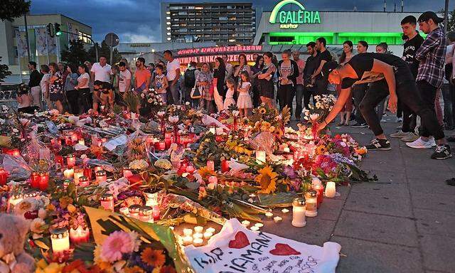 Archivbild: Trauernde Menschen und ein Blumenmeer beim Tatort in München