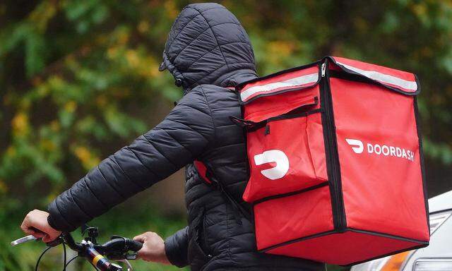 A delivery person for Doordash rides his bike in the rain during the coronavirus disease (COVID-19) pandemic in the Manhattan borough of New York City