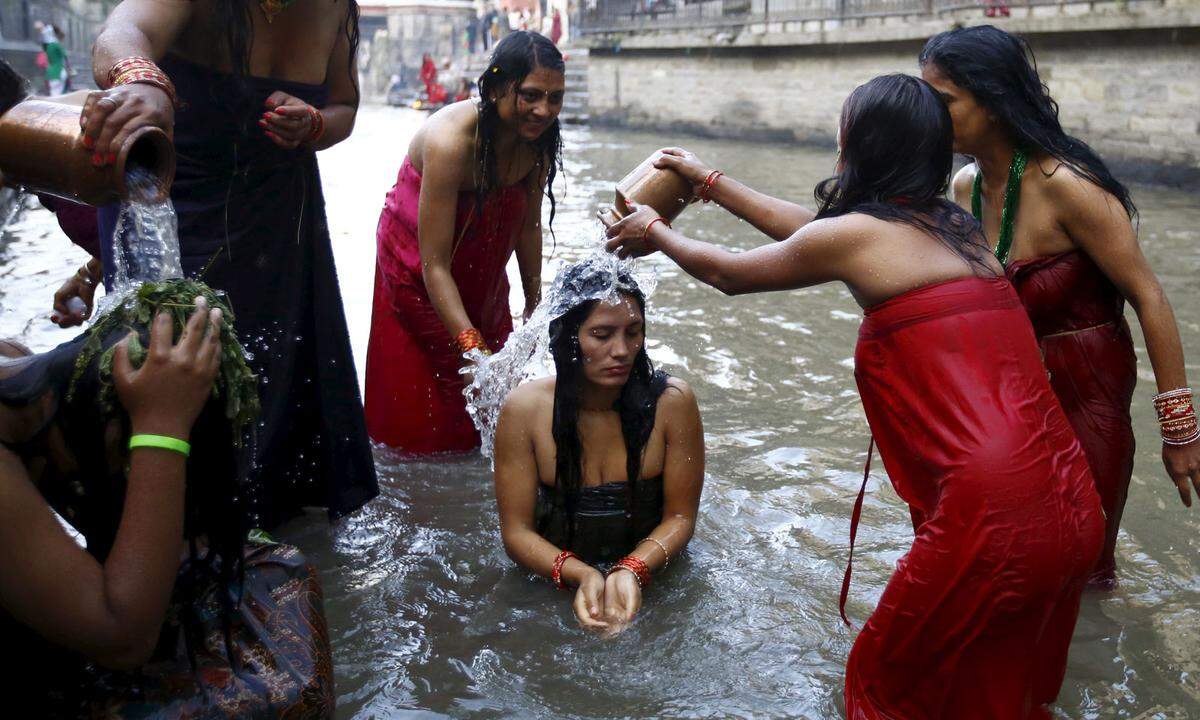 "Keine Kameras, keine Schuhe, keine Menstruierenden." Frauen, die ihre Periode haben, werden in vielen Kulturen nach wie vor als unrein diskriminiert - und sind z.B. in Tempelanlagen nicht willkommen. In Indien halten sich Tabus mit religiösem Ursprung genauso hartnäckig wie in Teilen Nepals: Frauen sind während ihrer Menstruation von der Gesellschaft ausgeschlossen.  Im Bild: Nepalesische Frauen beim heiligen Bad im Bagmati-Fluss. Während des Rishi Panchami-Festivals in Kathmandu bitten sie um Vergebung für die Sünde ihrer Menstruation.