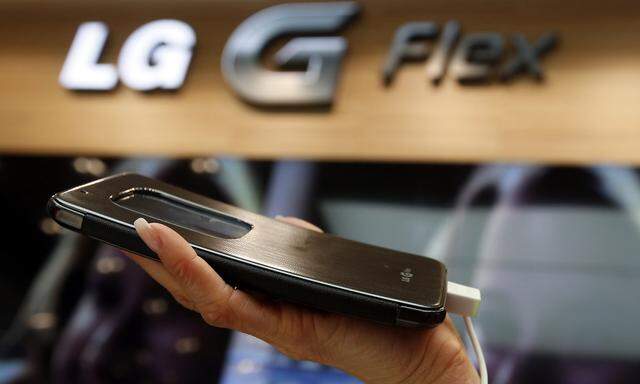 A model holds a curved G Flex smartphone by LG Electronics during the Mobile World Congress in Barcelona