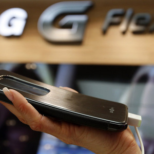 A model holds a curved G Flex smartphone by LG Electronics during the Mobile World Congress in Barcelona