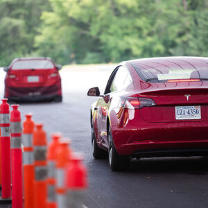 IIHS media relations associate Young demonstrates front crash prevention test on Tesla Model 3 at IIHS-HLDI Vehicle Research Center in Ruckersville, Virginia