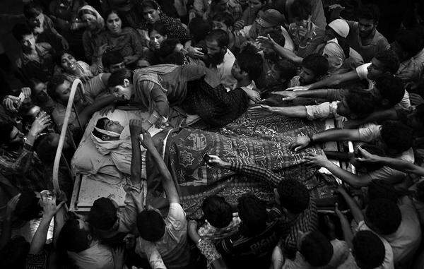 Altaf Qadri, Indien, AP Feroz Ahmad, alias Showkat, wurde in der Region Kashmir im September von Soldaten getötet. Bei seinem Begräbnis klettert seine Schwester auf das Bett, auf dem der Leichnam ihres Bruders zum Grab getragen wird.