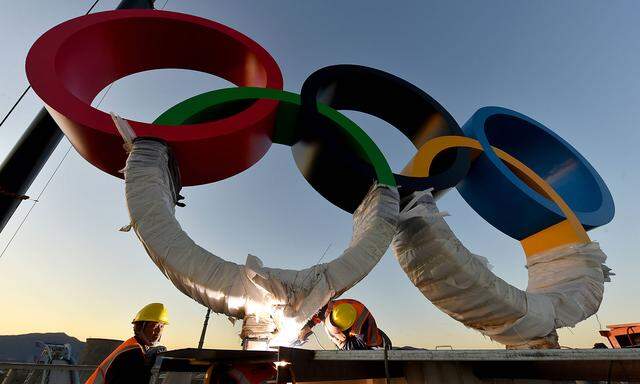 Bauarbeiter stellen Olympische Ringe auf
