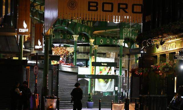 Armed police officers stand in Borough Market after an incident in the London Bridge area of London