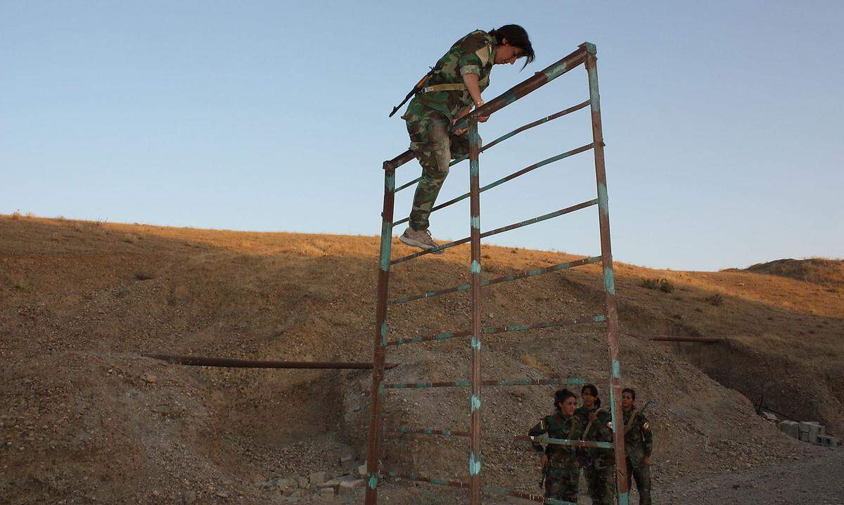 Als Teil ihres Trainings klettern die kurdischen Kämpferinnen über Hindernisse.