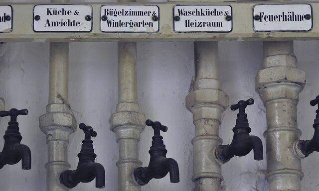 Alte Wasserhaehne in einem Keller deutsche Beschriftung der zugehoerigen Raeume iblsig01893752