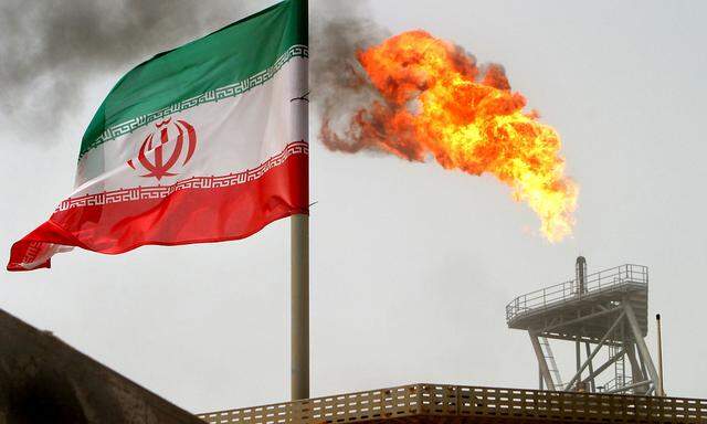 FILE PHOTO: A gas flare on an oil production platform in the Soroush oil fields is seen alongside an Iranian flag in the Gulf