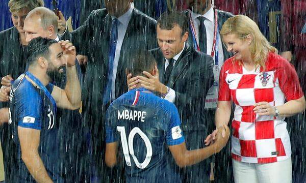 Erst später fanden sich auch Schirme für Macron und Grabar-Kitarovic. Den Spielern wie Mbappé war's ohnehin egal, aber auch die Staatsgäste ließen sich die Stimmung offensichtlich nicht verderben.