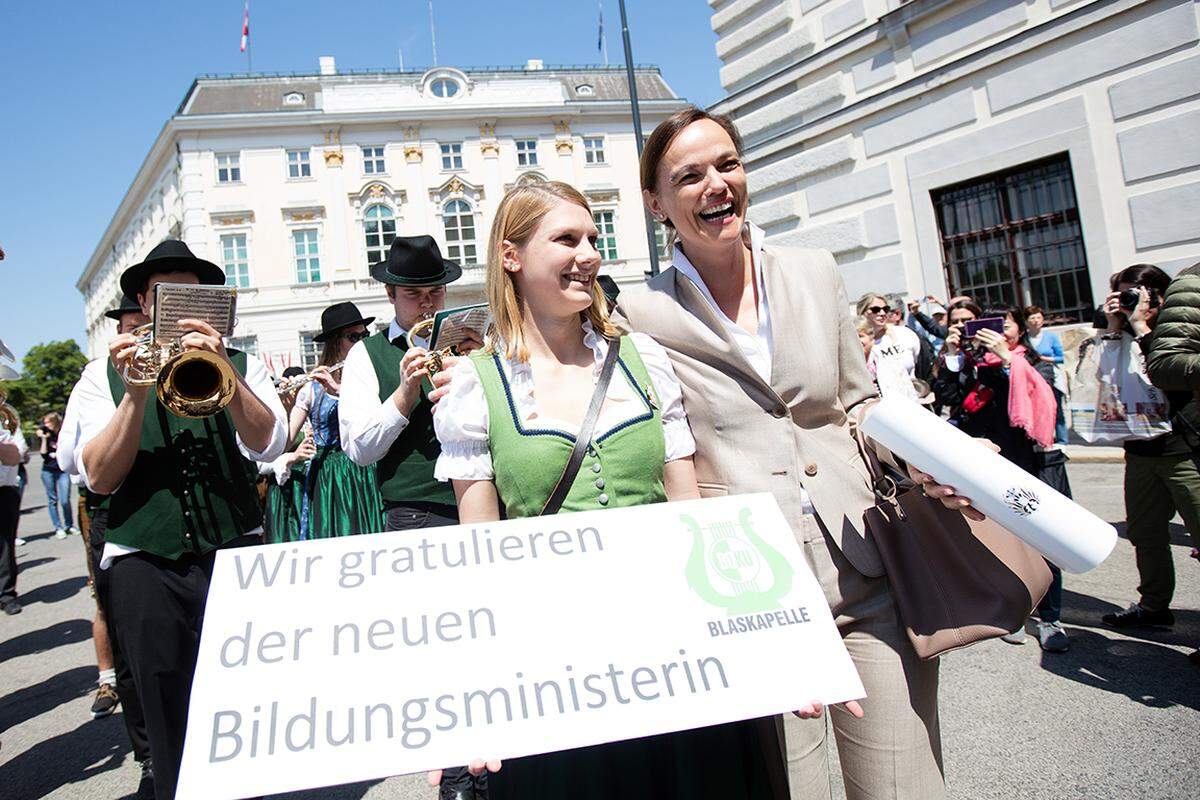 Vor der Hofburg wurden die neuen Regierungsmitglieder von der Blaskapelle der Universität für Bodenkultur und zahlreichen Schaulustigen empfangen. Die Kapelle spielte für die neue Bildungsministerin auf, denn sie war bereits öfters an der Veterinärmedizinischen Universität (deren Rektorin Hammerschmid war) zu Gast, wie die Musiker erklärten.