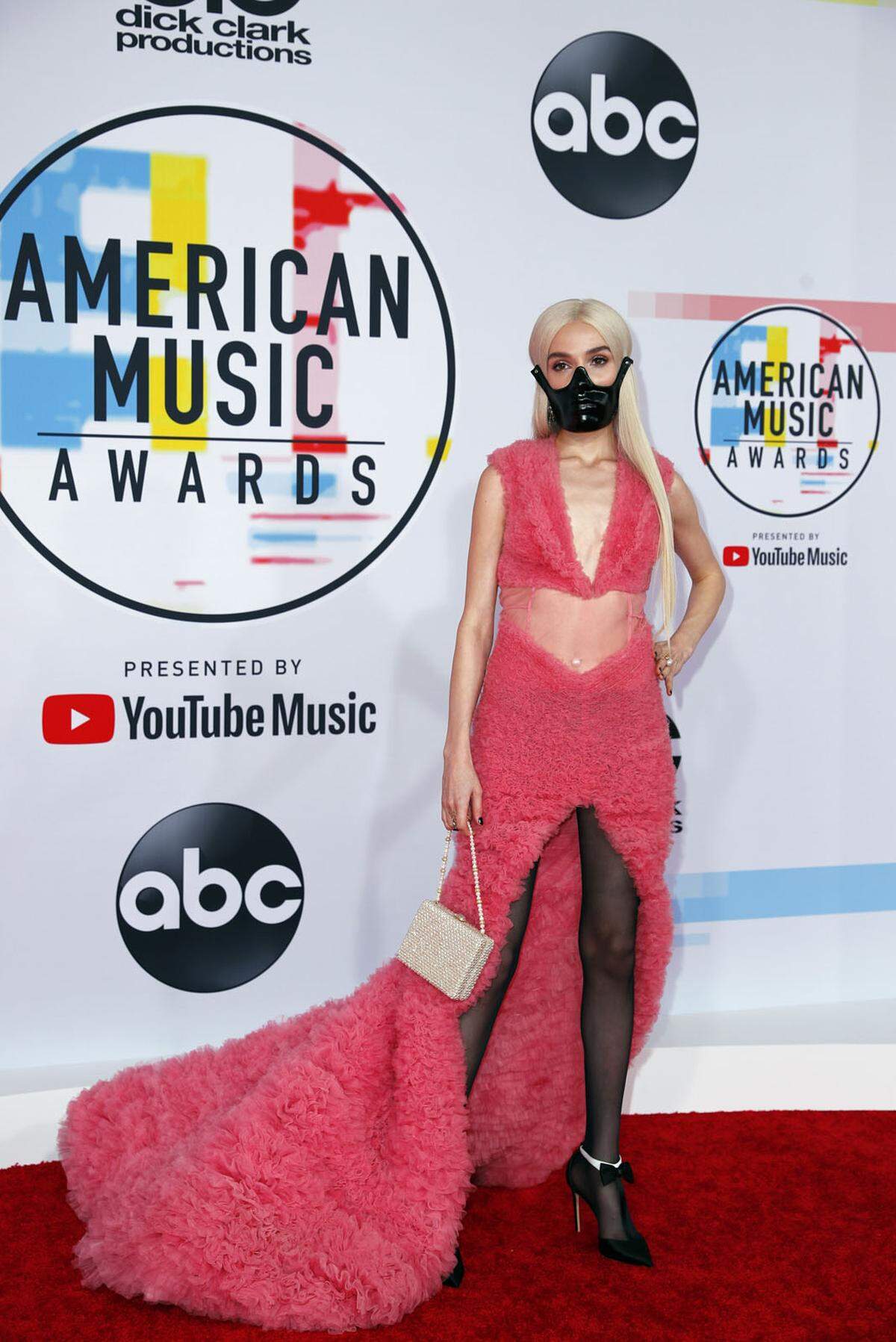 Auf dem roten Teppich der American Music Awards kann man sich modisch austoben und auch gewagte Looks präsentieren. Den Bogen überspannt hat aber Musikerin Poppy, die zu ihrem pinken Kleid eine Art Maulkorb trug.    