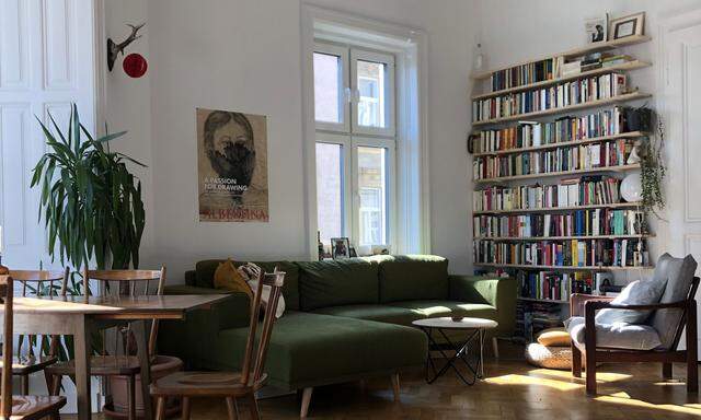 Im Wohnzimmer steht ein Bücherregal aus einfachen Fichtenholzbrettern.