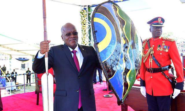 FILE PHOTO: FILE PHOTO: Tanzania's re-elected President John Pombe Magufuli holds a spear and shield from the elders after he was sworn-in for the second term at the Jamhuri stadium in Dodoma