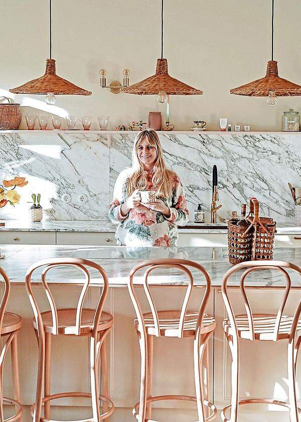 Leni Tornquist in der Küche mit sieben Sesseln an der Theke –  dem Zentrum der Wohnung.