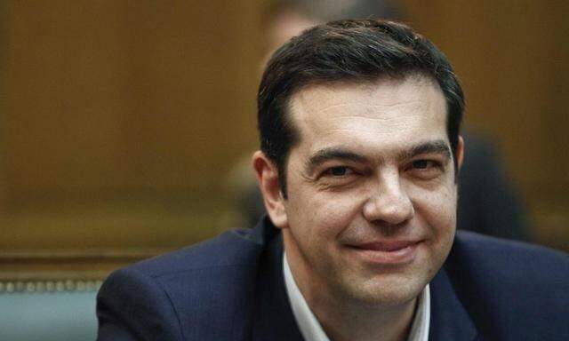 Greek PM Tsipras smiles as he attends the first meeting of the new cabinet in the parliament building in Athens