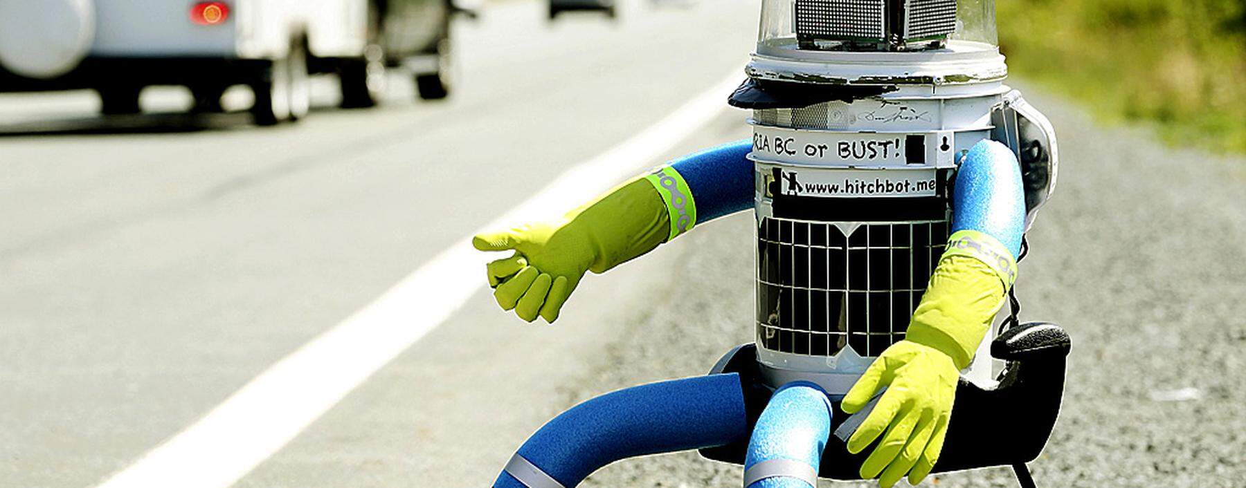 The anthropomorphic robot named hitchBOT sits on the shoulder of Highway 102 to begin its 6000 kilometer cross country journey outside of Halifax