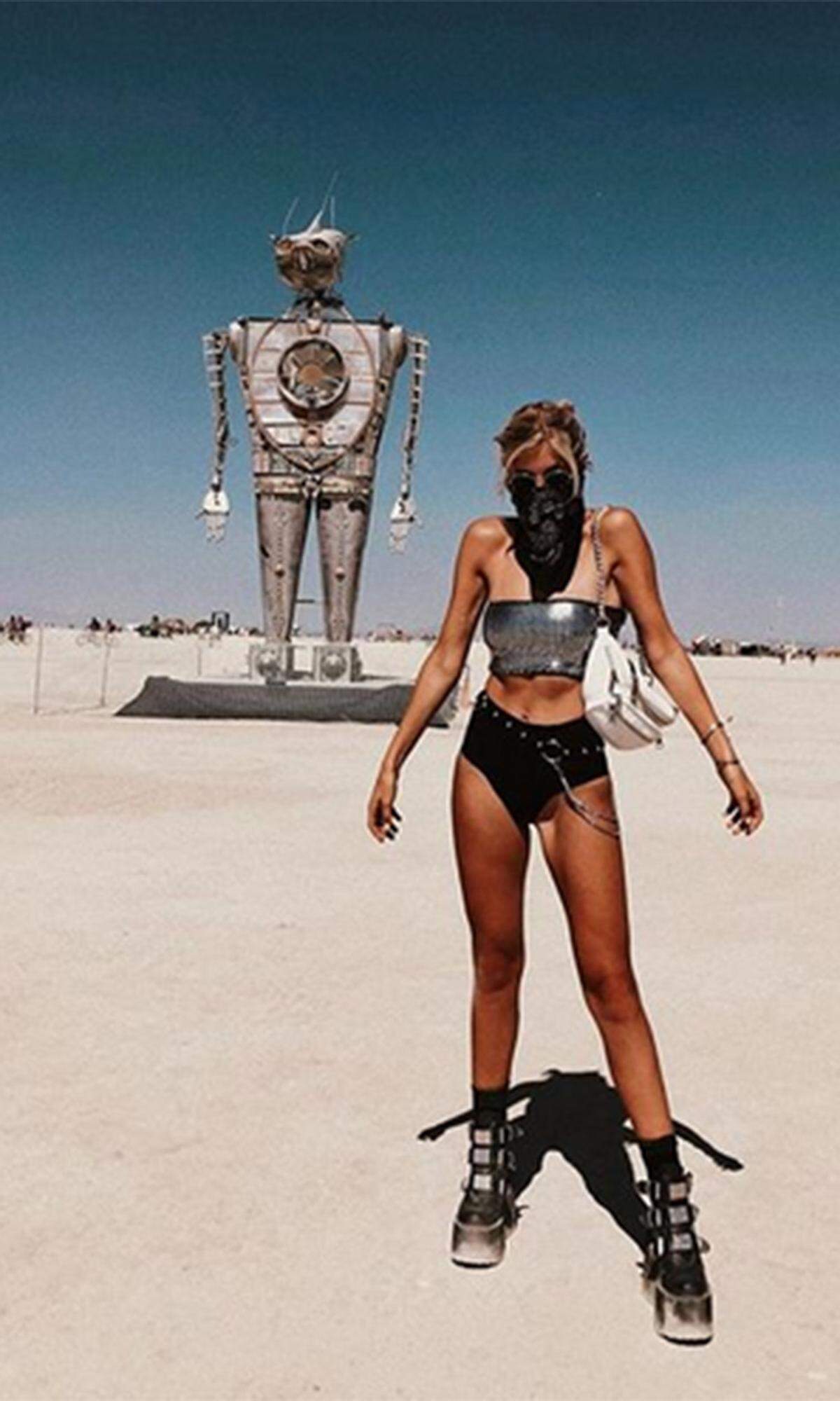 Das heurige Styling-Motto „I-Robot“ dürfte Influencerin Xenia Overdose zu diesem knappen Outfit inspiriert haben: Metallic-Bandeau-Top, Hot-Pants (oder eher Bikinihose) und derbe Plateau-Boots mit Schnallen.
