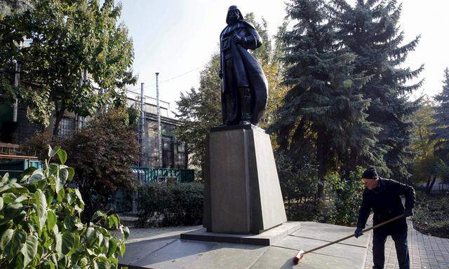 A worker sweeps leaves off a monument to the character Darth Vader from ´Star Wars´, which was rebuilt from a statue of Soviet state founder Vladimir Lenin, in Odessa
