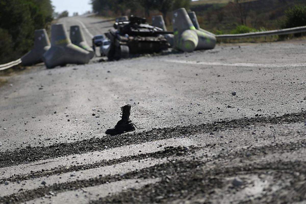 ... denn jede Stunde kann die letzte sein. Laut OSZE fielen dem Ukraine-Krieg bisher mindestens 5500 Menschen zum Opfer (im Hintergrund: zerstörter Panzer).