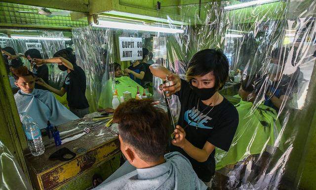 Auf den Philippinen haben Friseure Plastikvorhänge montiert, um der Virenverbreitung vorzubeugen.