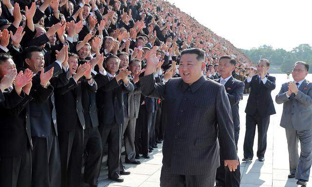 Kim Jong-un lässt sich in Pjöngjang  vor Wissenschaftlern und Gesundheitspersonal fotografieren.