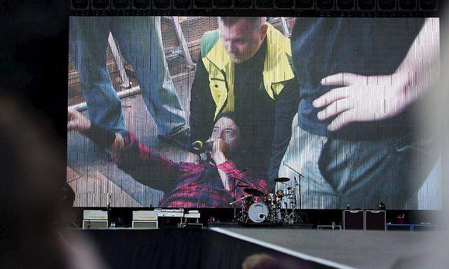 Foo Fighters band member Dave Grohl is seen on a big screen talking on a microphone after falling from the stage during the band´s concert at Nya Ullevi in Gothenburg