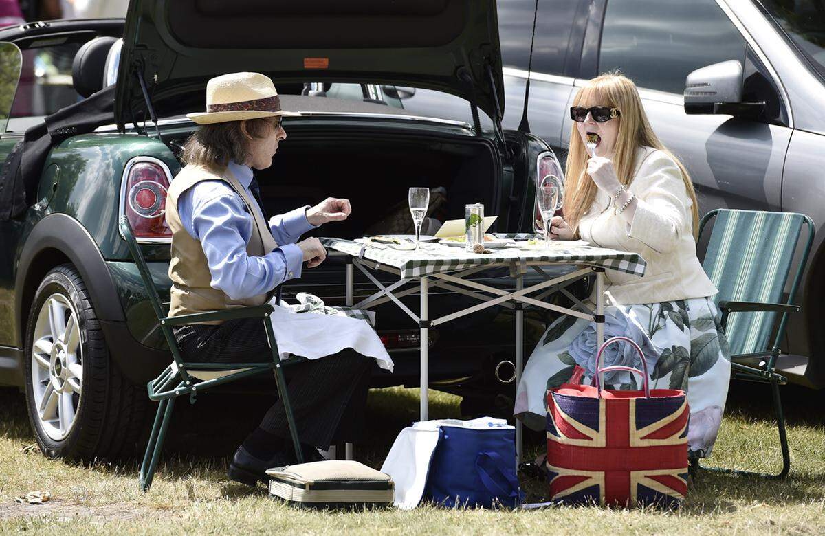 Stilecht hält dieses Pärchen ein Picknick aus dem Kofferraum.