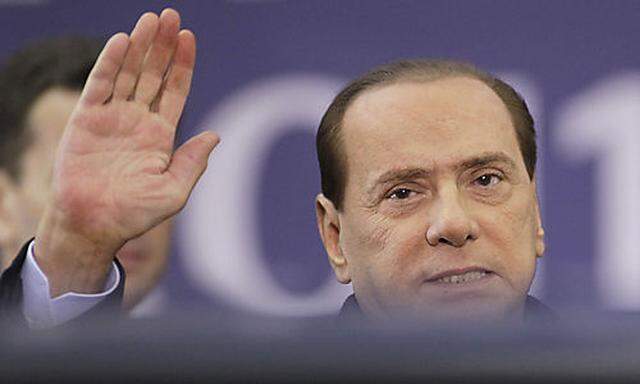 Italian Prime Minister Silvio Berlusconi waves as he arrives for a working dinner, part of the G20 su