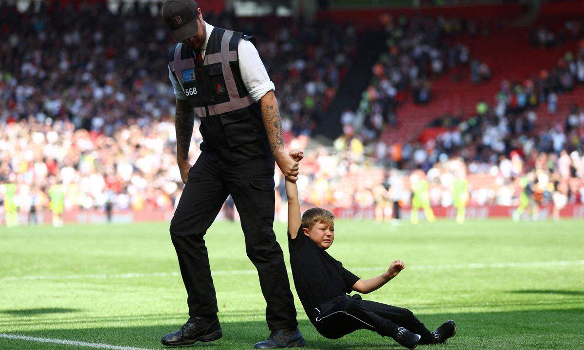 27. August. Ein junger Spielfeld-Flitzer wird nach dem Match Southampton gegen Manchester United gewaltsam vom Spielfeld im St Mary's Stadium, Southampton, entfernt