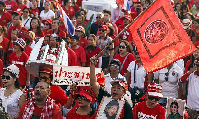 Members of the pro-government ´red shirt´ group sing Thailand´s national anthem during a rally in Nakhon Pathom province on the outskirts of Bangkok