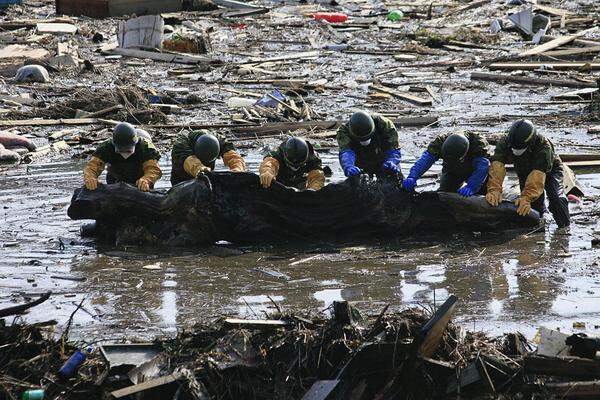 Freitag (4. April): Soldaten mühen sich in Ishinomaki auf der Suche nach Vermissten durch die Trümmer.