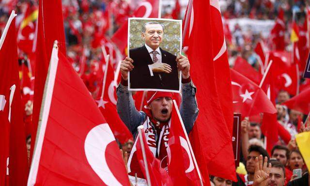 A supporter of Turkish President Erdogan holds up a picture during a pro-government protest in Cologne