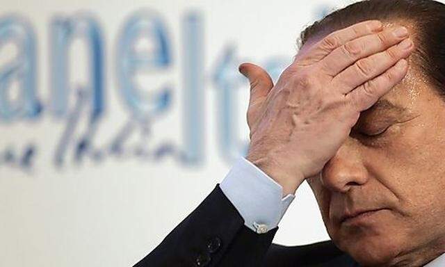 File photo of Forza Italia leader Berlusconi touching his head as he makes a speech during a Giovane