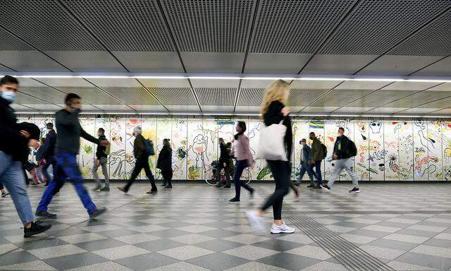Menschen gehen durch eine U-Bahn-Station.