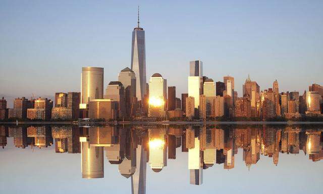 Skyline of Lower Manhattan reflected in calm Hudson River with skyscraper of One World Trade Center