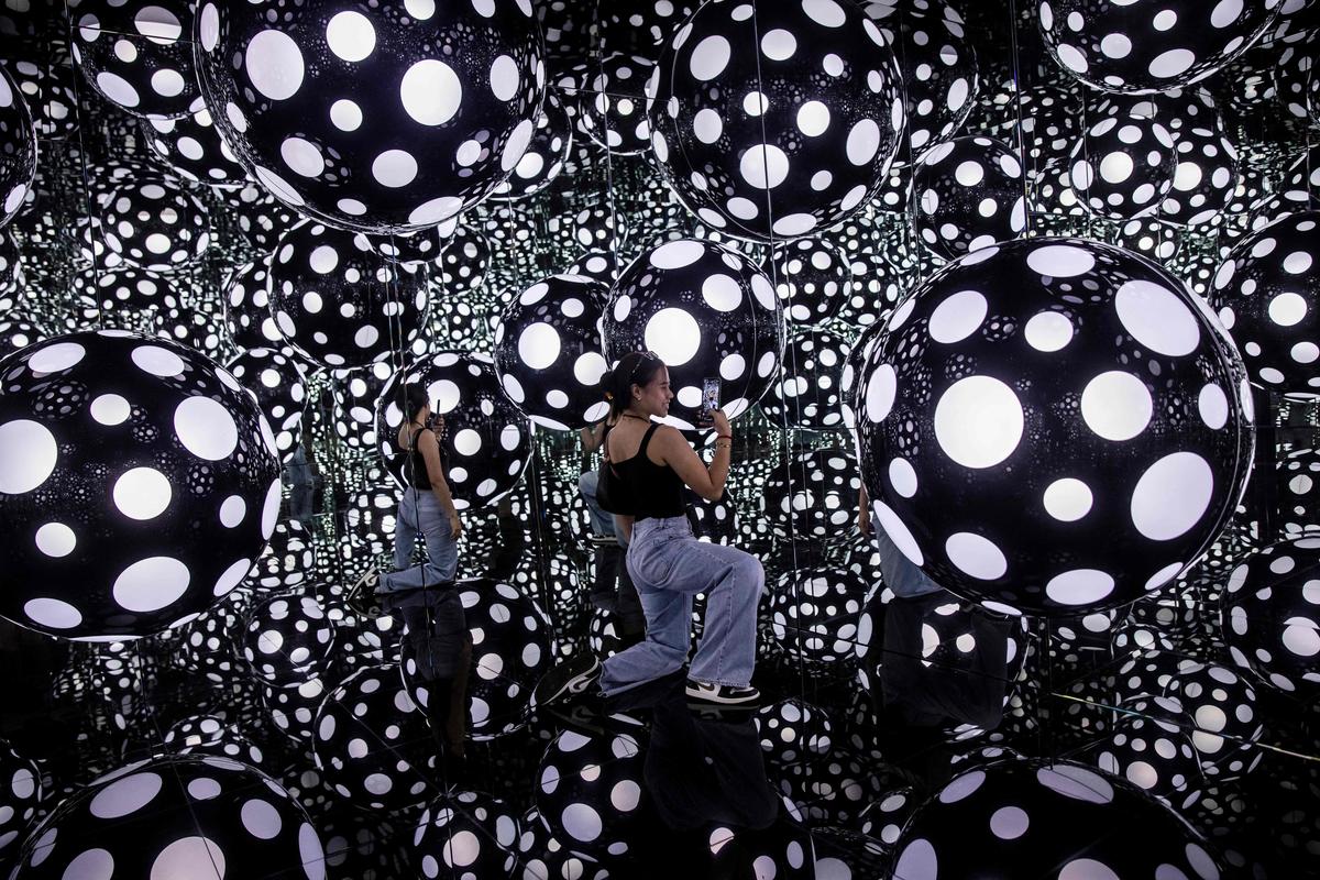 4. August. Eine Frau posiert in einer Installation der japanischen Künstlerin Yayoi Kusama in Hong Kong.
