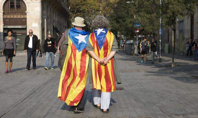 Die Ruhe vor dem nächsten Sturm? Katalanische Unabhängigkeitsaktivisten schlendern durch die Straßen Barcelonas. 