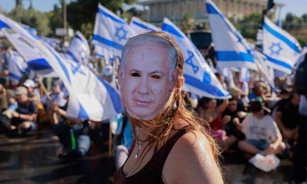 Ein Demonstrant vor der Knesset trägt eine Maske mit den Zügen von Premierminister Benjamin Netanyahu. Israels Parlament hat diese Woche eine höchst umstrittene Justizreform beschlossen. Zehntausende protestieren seit Wochen dagegen. 