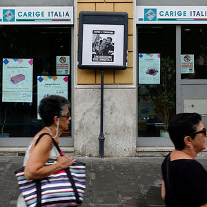 People walk past a Carige bank in Rome