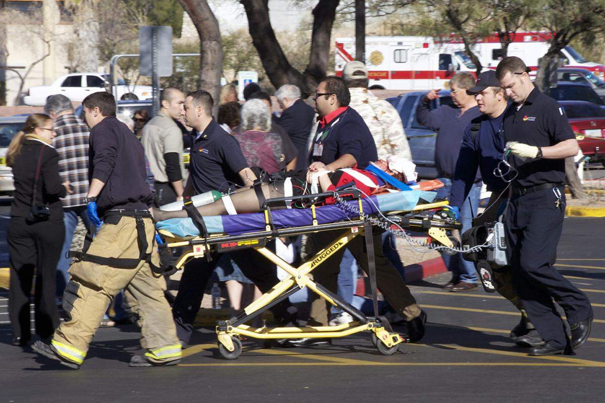 Sechs Menschen sterben im Kugelhagel vor einem US-Supermarkt, die Abgeordnete Giffords wird schwer verletzt abtransportiert (Bild).