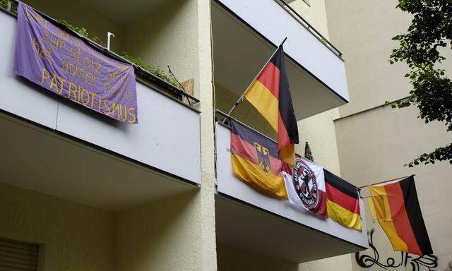 Deutschlandfahnen schmuecken ein Wohnhaus in der Schoenleinstrasse in Berlin Kreuzberg snapshot photog