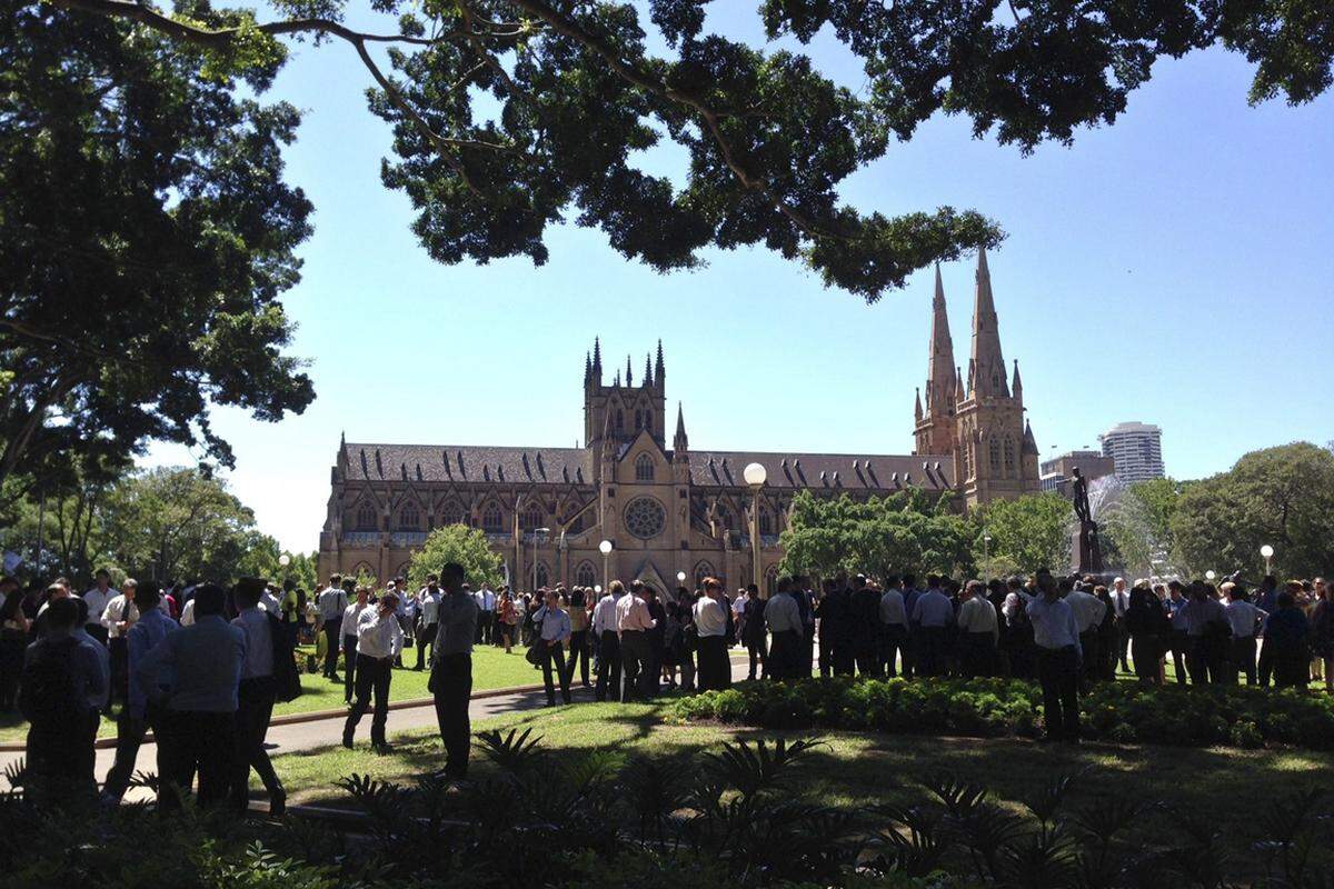 Im nahen Hyde Park (mit der St. Mary's Cathedral im Hintergrund) sammeln sich viele der Menschen, die aus dem gefährdeten Bereich rund um Martin Place in Sicherheit gebracht wurden. Die Polizei hat hier eine Informationsstelle eingerichtet, um Menschen weiterzuhelfen, die Hilfe benötigen.