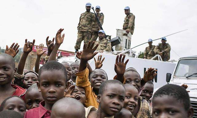 Congolese children gather in front of a UN peacekeeping tank during the global rally 'One Billion Rising' which is part of a V-Day event calling for an end to gender-based violence, in Bukavu