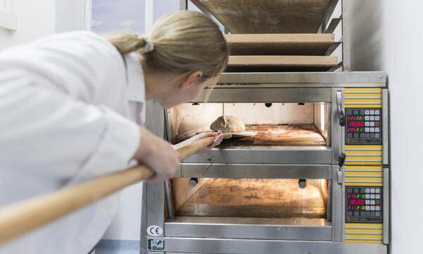 Backen im Labormantel: Lisa Staubmann schiebt das Brot in den Ofen. 